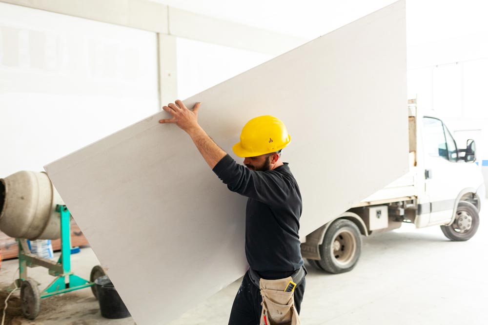 Worker builds a plasterboard wall | Featured image for the Working with Plasterboard blog from BetaBoard