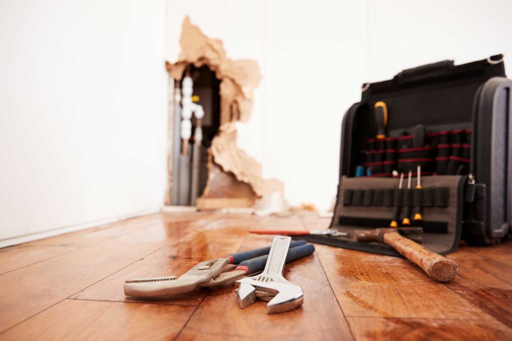 Tools and toolbox on a water damaged timber floor | Featured image for Fixing a Water Damaged Wood Floor blog by BetaBoard.