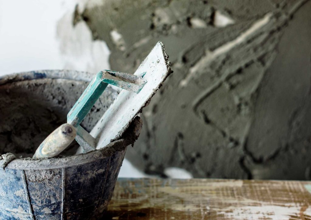 Plastering trowel sitting in a bucket | Featured image for the Plastering Tool Kit blog from BetaBoard.