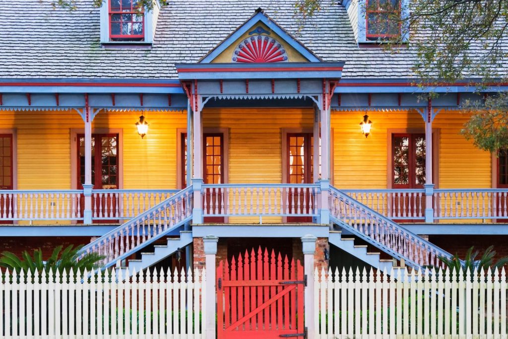 Colourful home with lights on the porch | Featured image for the Renovating a Queenslander Home Facade blog from BetaBoard.