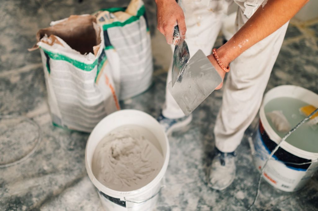 Builder Handling Compound with Trowel | Featured image for the Plasterboard Jointing Compound vs Plaster What You Need to Know blog by BetaBoard.